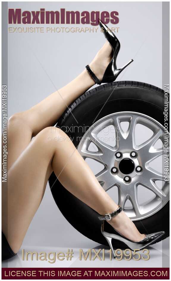 Sexy Woman Legs on a Car Tire