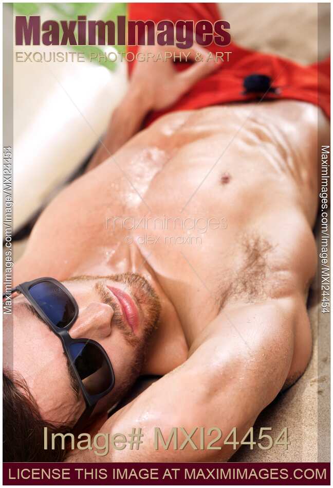 Sexy young man lying at the beach
