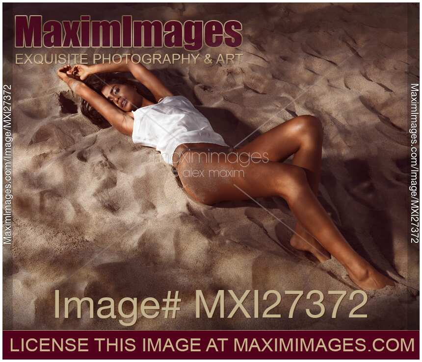 Sexy young woman lying on beach sand at night