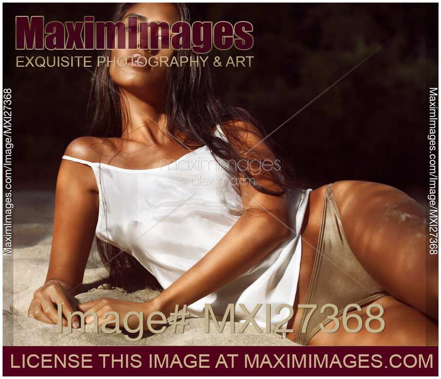 Sexy young woman lying on beach sand