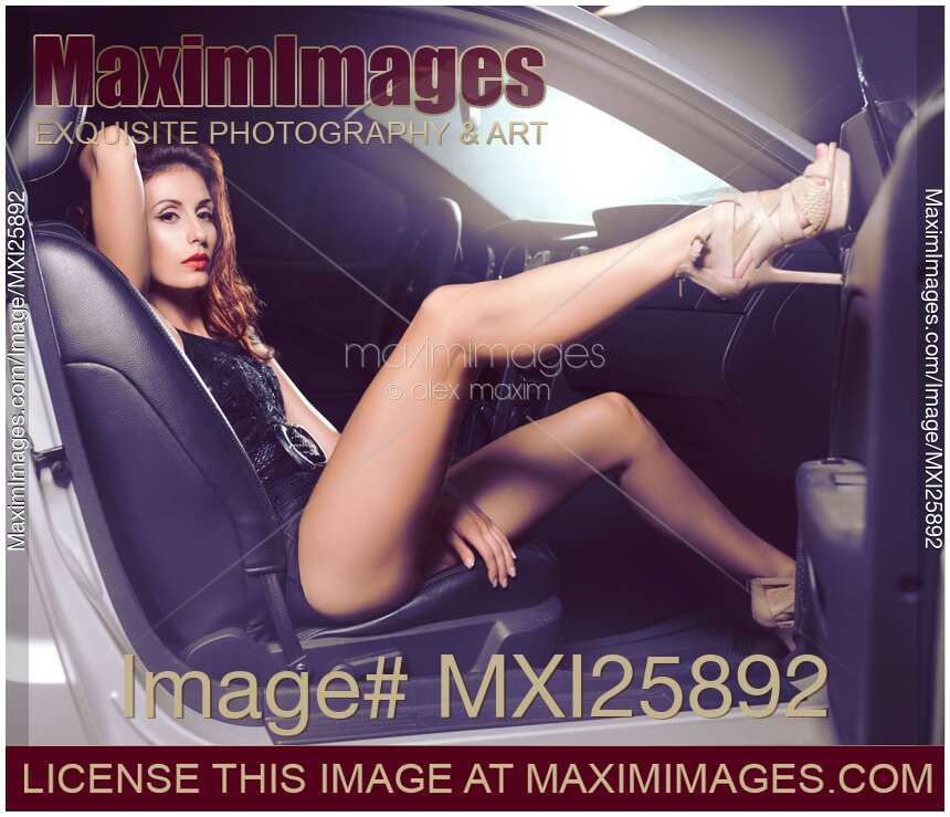 Sexy Young Woman Sitting in a Car