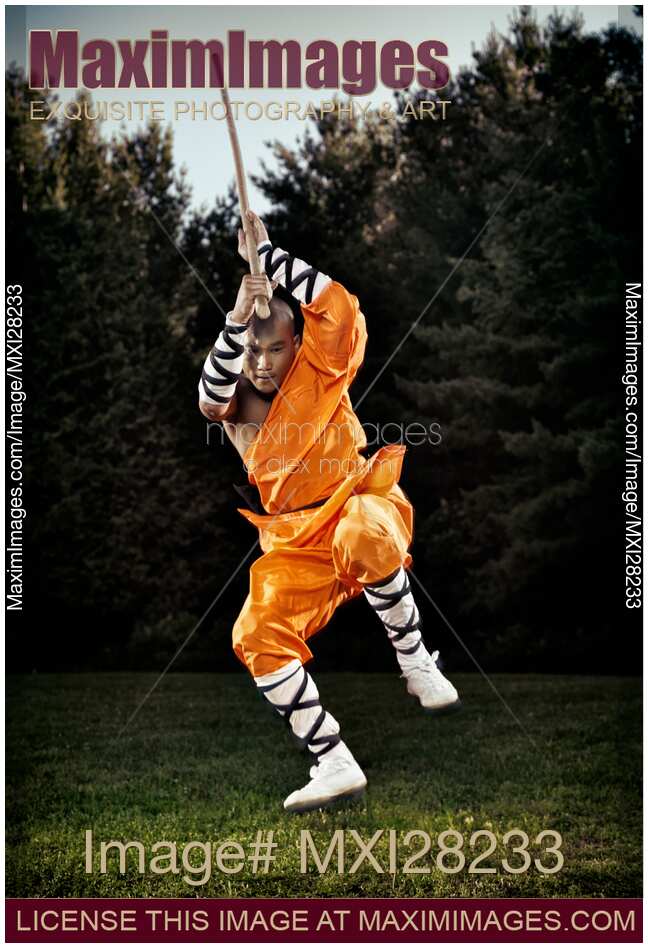 Shaolin warrior monk jumping with a staff