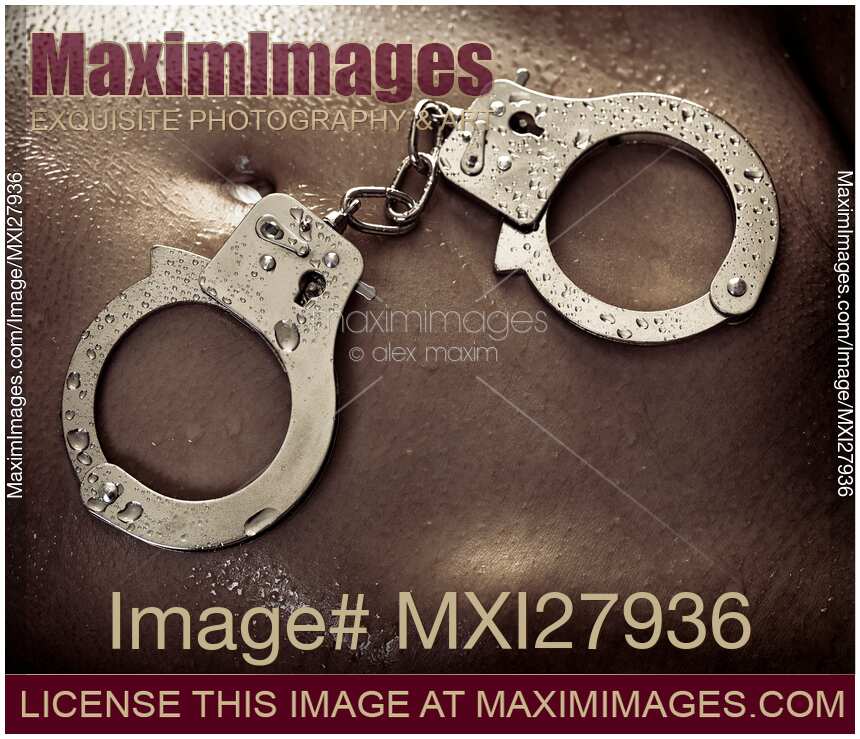 Shiny handcuffs on wet naked woman body
