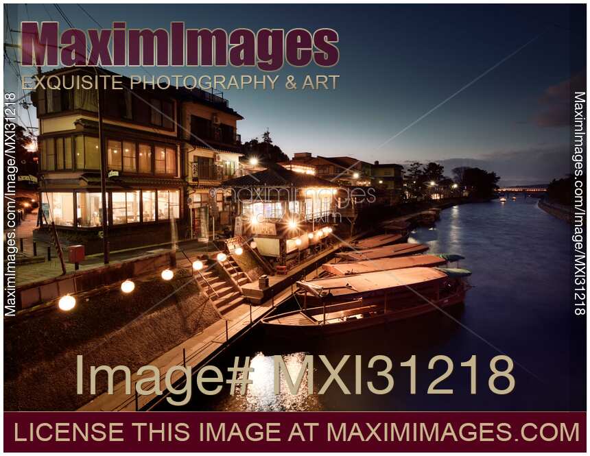 Sightseeing pleasure cruise boats at the bank of Uji River in nighttime city scenery Japan