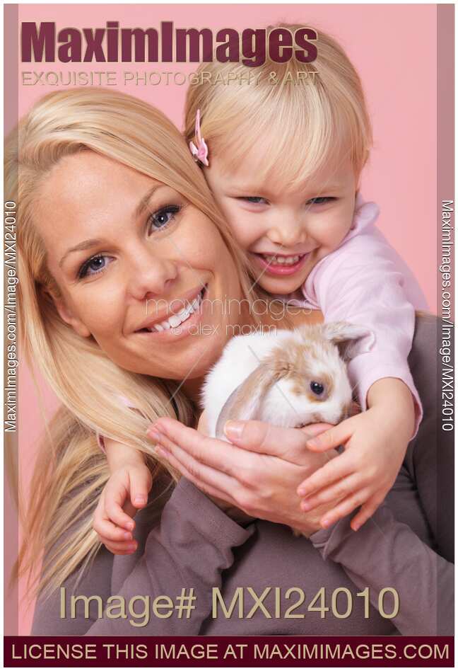 Smiling mother and daughter with a bunny
