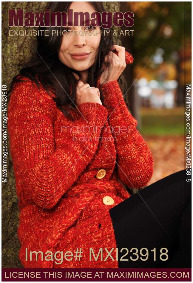 Smiling Woman Cuddling in a Sweater in the Wind