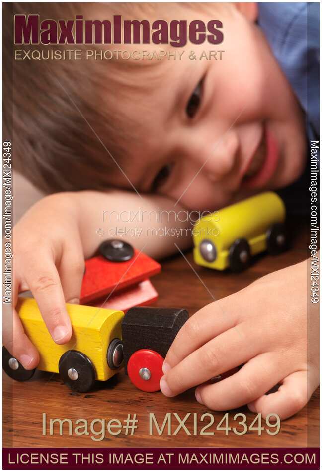Smiling young boy plaing with a toy train