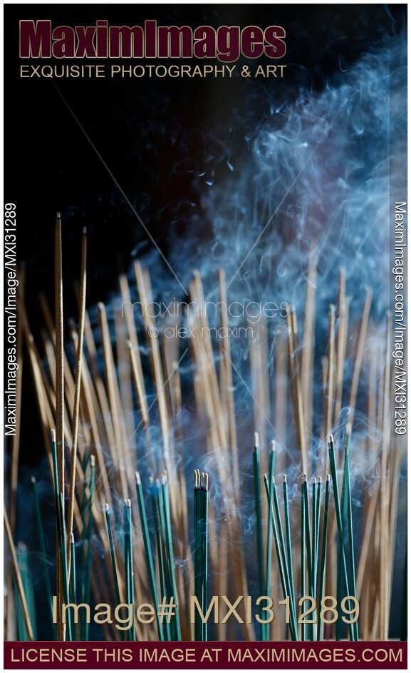 Smoke from incense joss sticks in a Japanese temple lit by sunlight