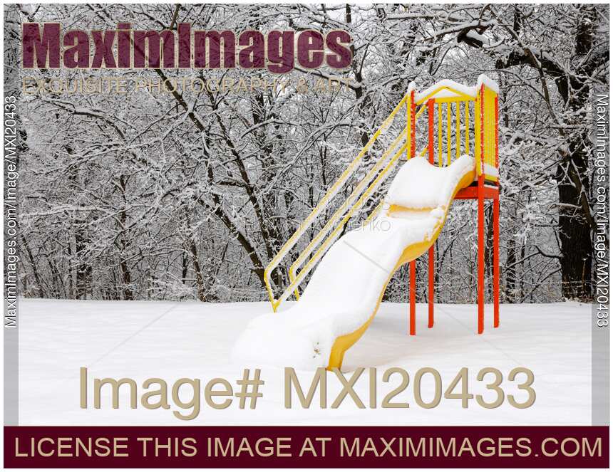 Snow covered slide on playground in winter