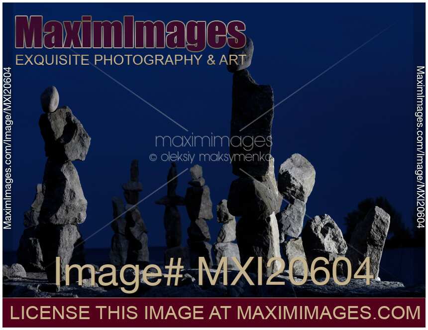 Stone figures over dark night sky