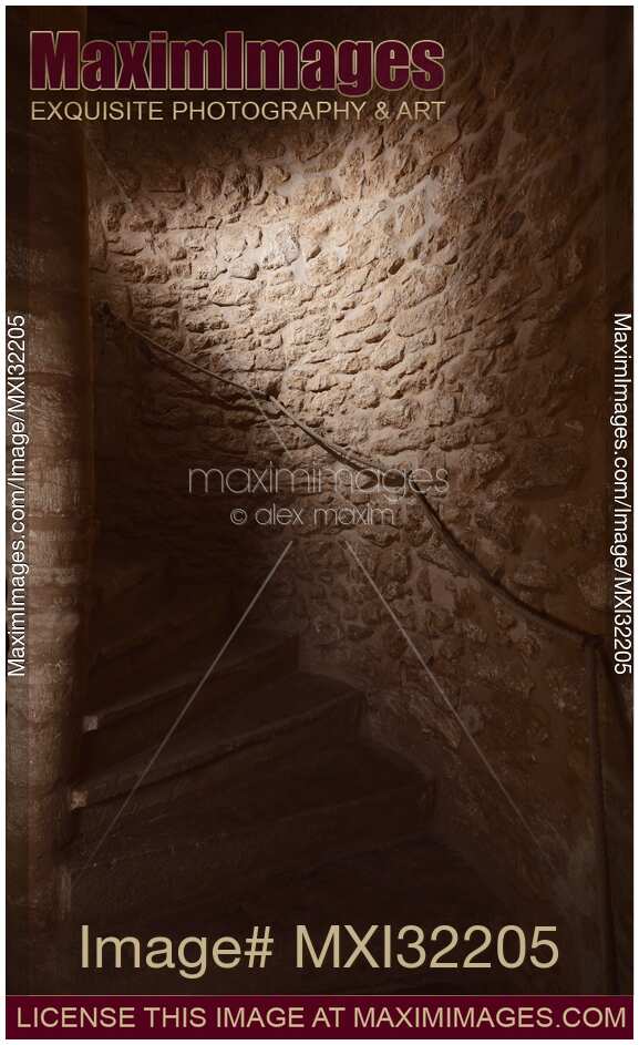 Stone steps of a spiral staircase in a dungeon of a medieval house