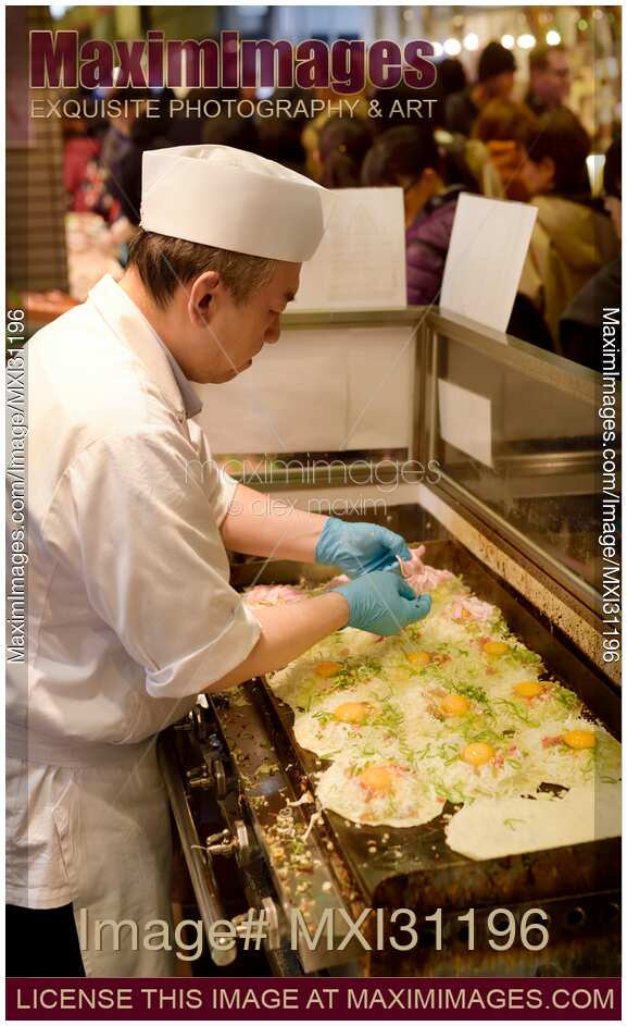 Street food vendor cooking Okonomiyaki pancakes at Nishiki market in Japan