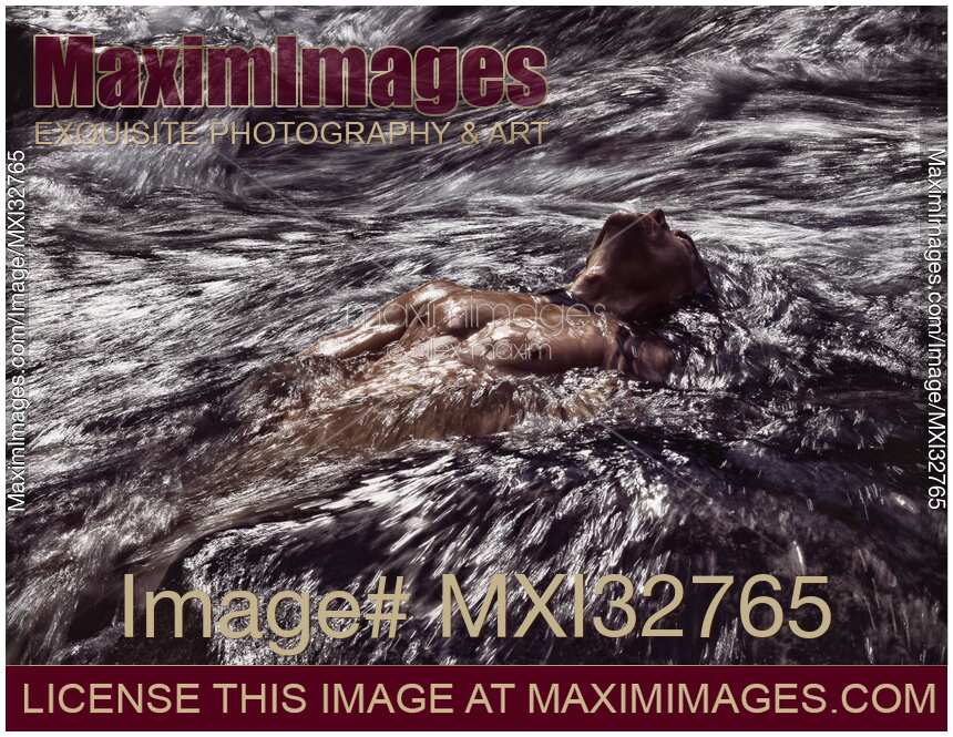 Strong muscular naked male body wet bare torso carried by turbulent river water or stormy sea waves