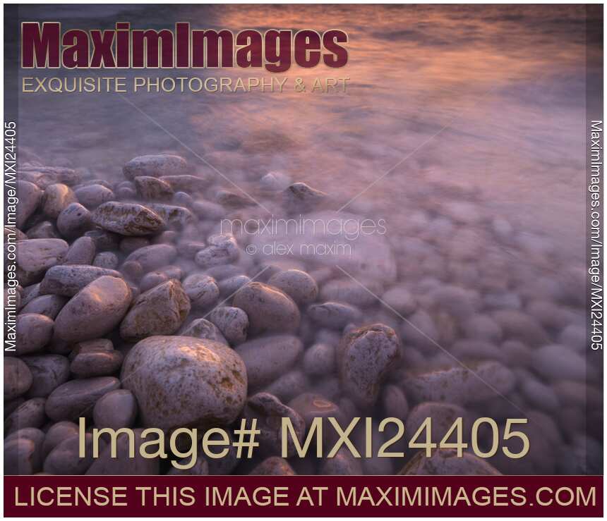 Sunset reflecting in water of a rocky shore