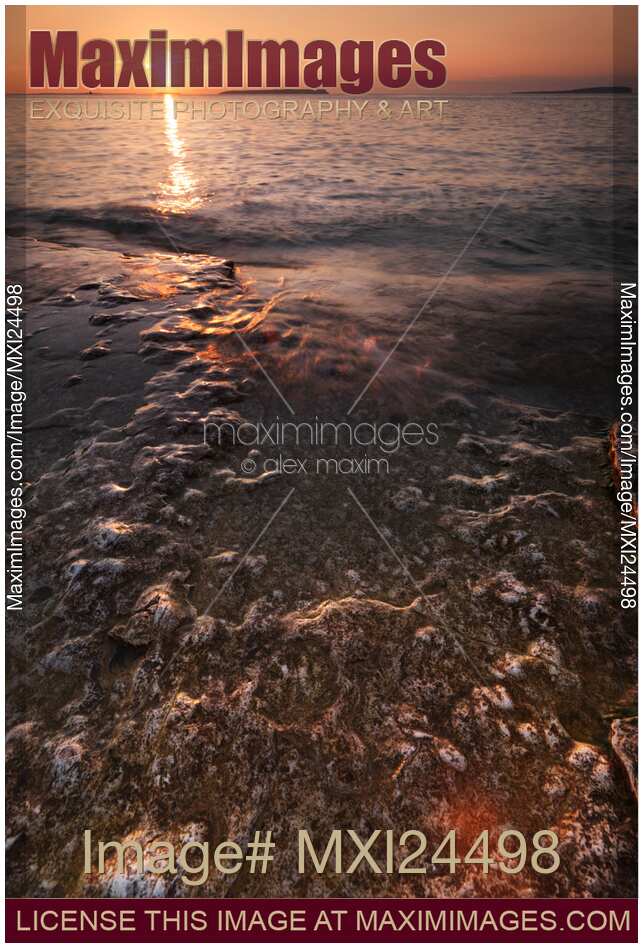 Sunset scenery of waves hitting rocks