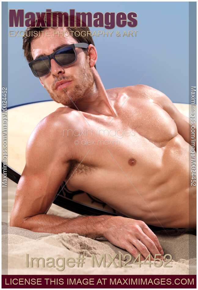 Surfer in sunglasses lying on the beach