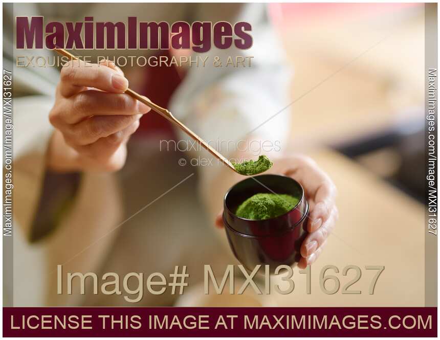 Tea ceremony master holding a bamboo spoon Chashaku of matcha green tea powder