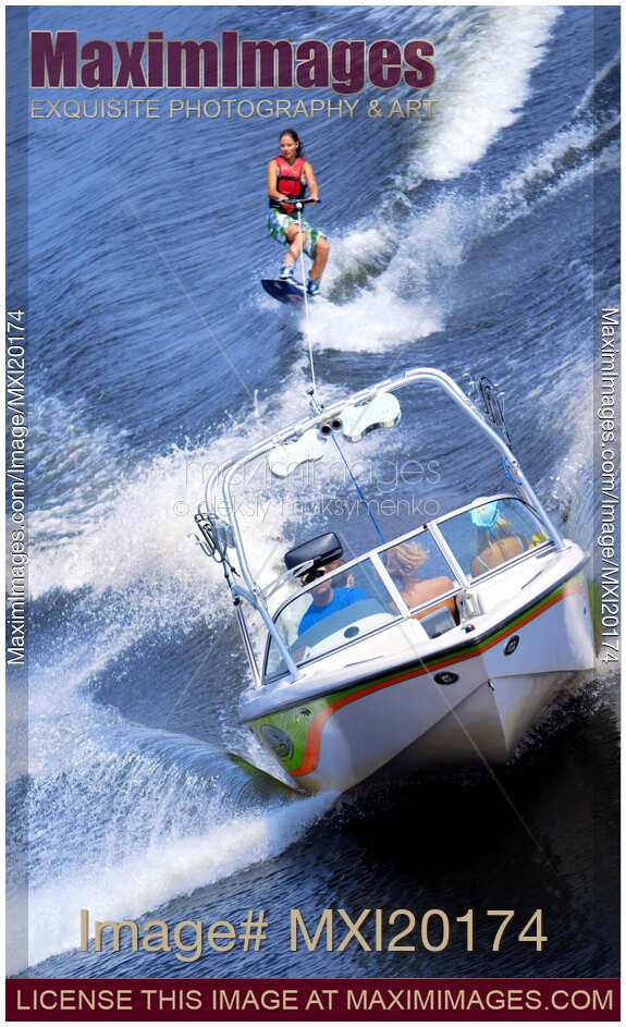 Teenage Girl Riding Wakeboard Behind Motorboat
