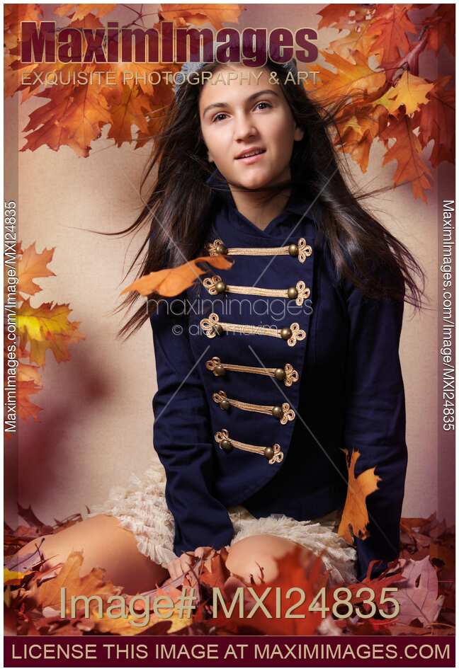 Teenage girl surrounded with autumn leaves