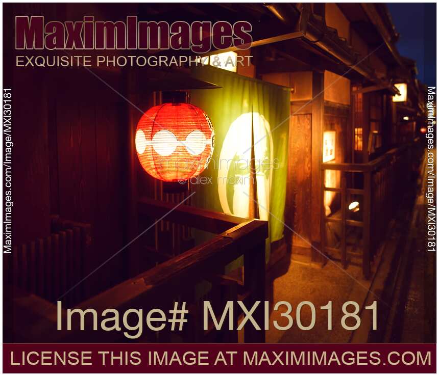 Traditional teahouse red lantern by the entrance door lit up at night in Gion Kyoto
