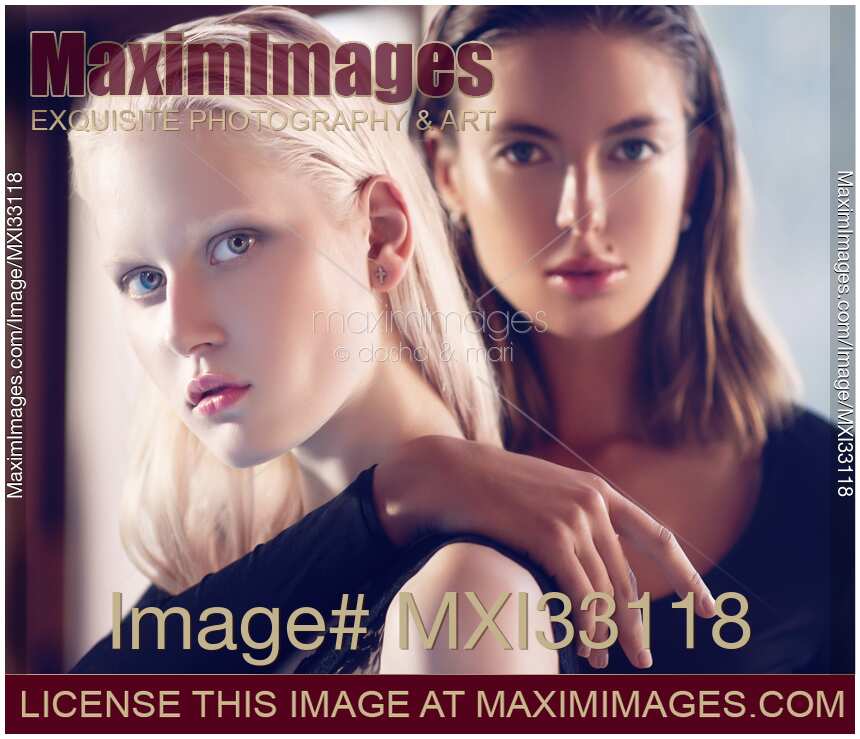 Two beautiful women blond and brunette female couple with sleek stylish fashionable look