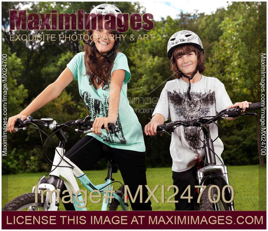 Two children brother and sister on thier bikes in helmets