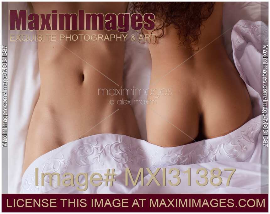 Two girls Sexy lesbian couple lying together on bed sheets sensual close-up of naked bodies