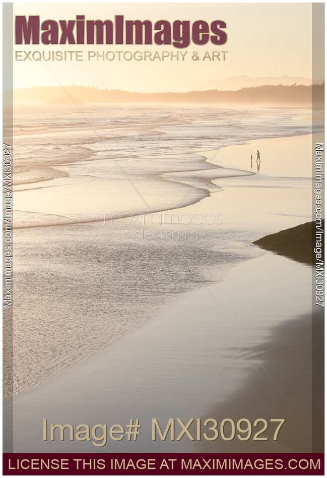 Two people on the ocean beach in sunset at Pacific Rim National Park Tofino