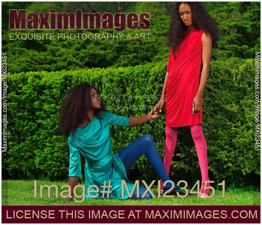 Two Women Wearing Bright Dresses in a Park