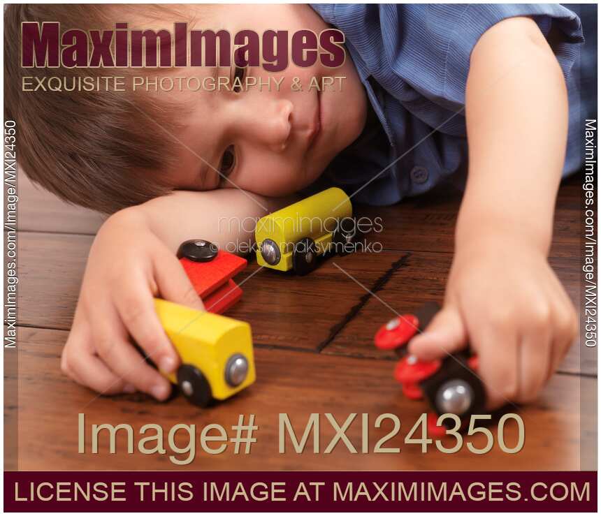 Two year old boy playing with a train