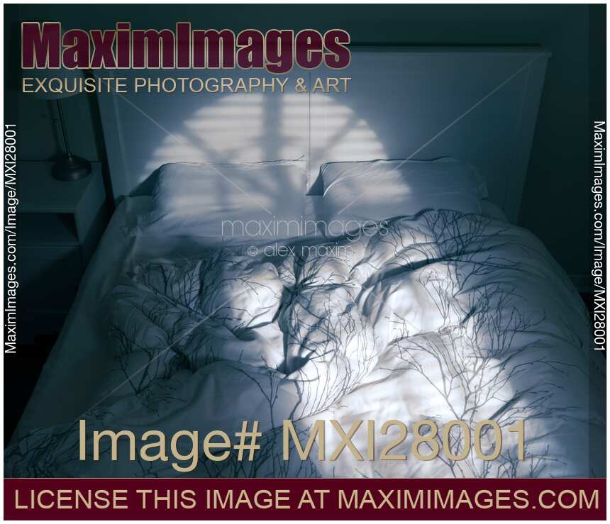 Unmade bed with light coming from a window