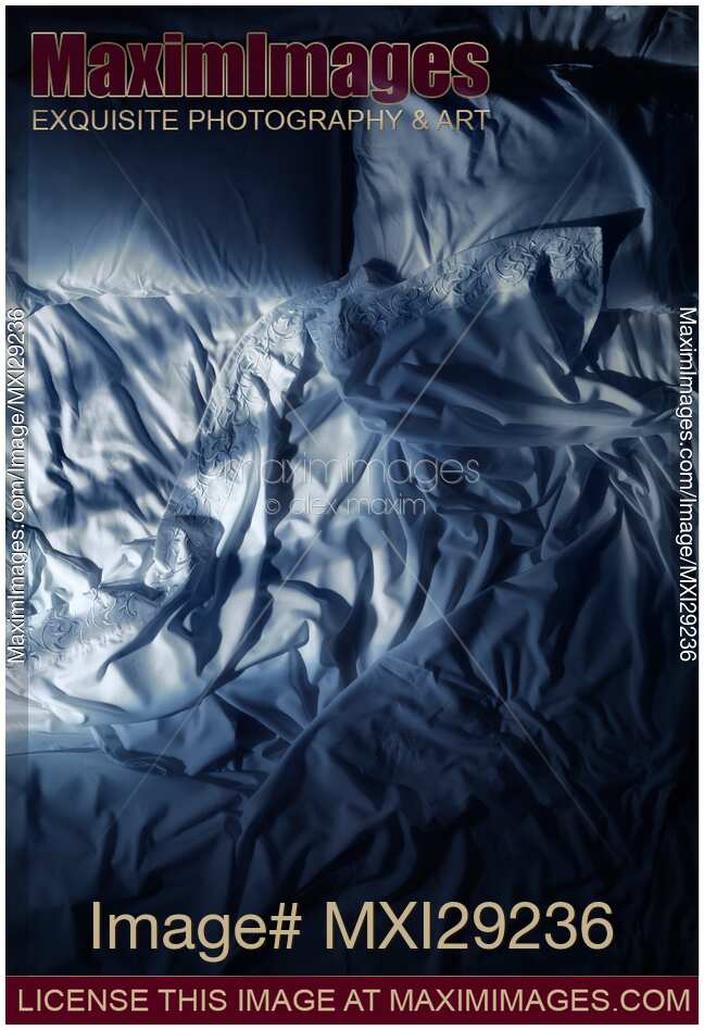 Unmade empty bed at night