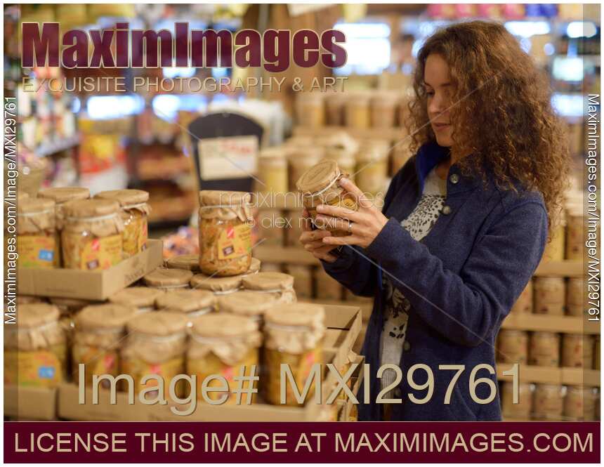 Woman at a grocery store looking at canned food products