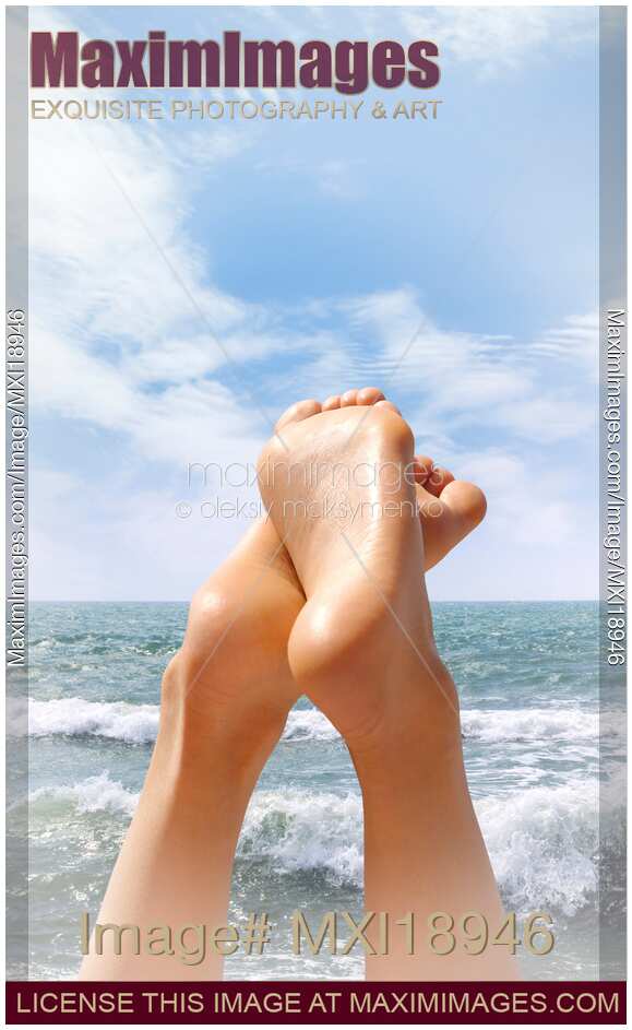 Woman at the beach feet on blue sea background