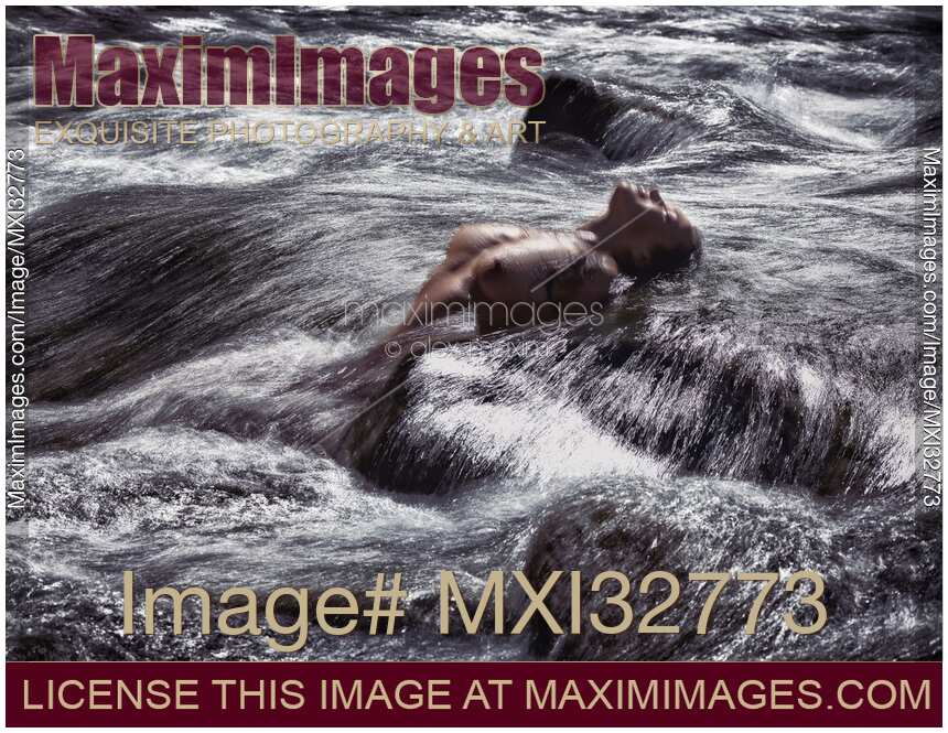 Woman bathing naked in wild water of a river or stormy sea with her wet nude body and breasts arching above water