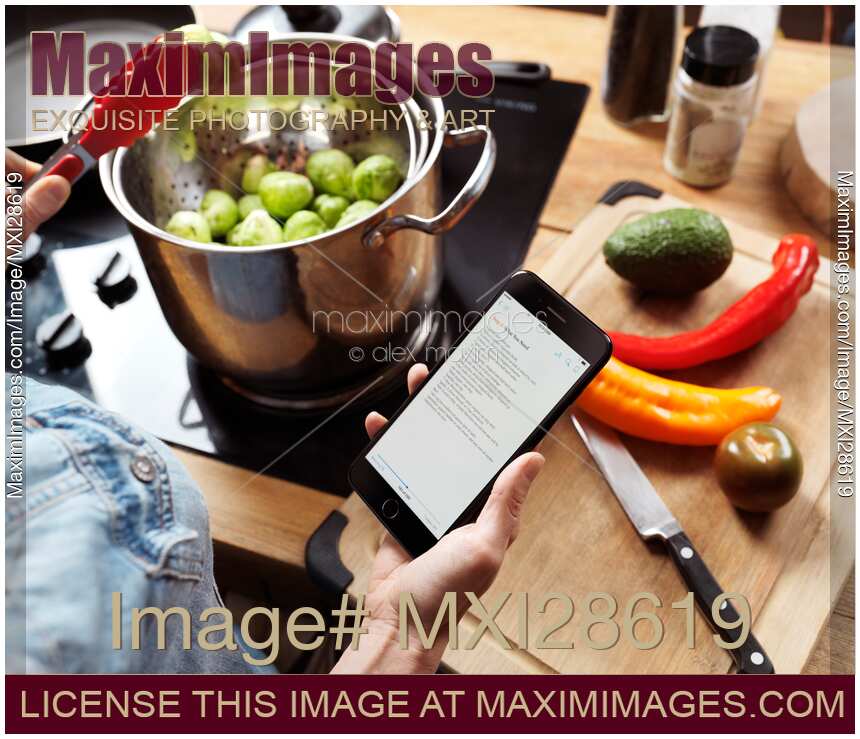 Woman cooking reading recipe from iPhone 7