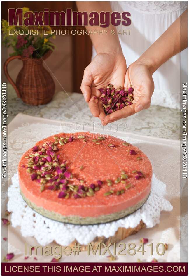 Woman decorating home made cake with flowers