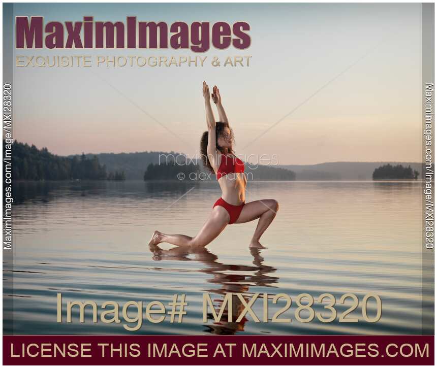 Woman doing Hatha yoga Anjaneyasana Low Lunge pose on the water