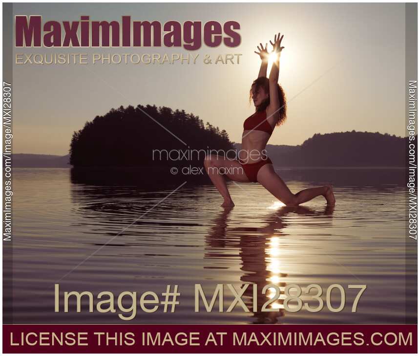 Woman doing yoga Anjaneyasana Low Lunge pose on the water in morning sunlight