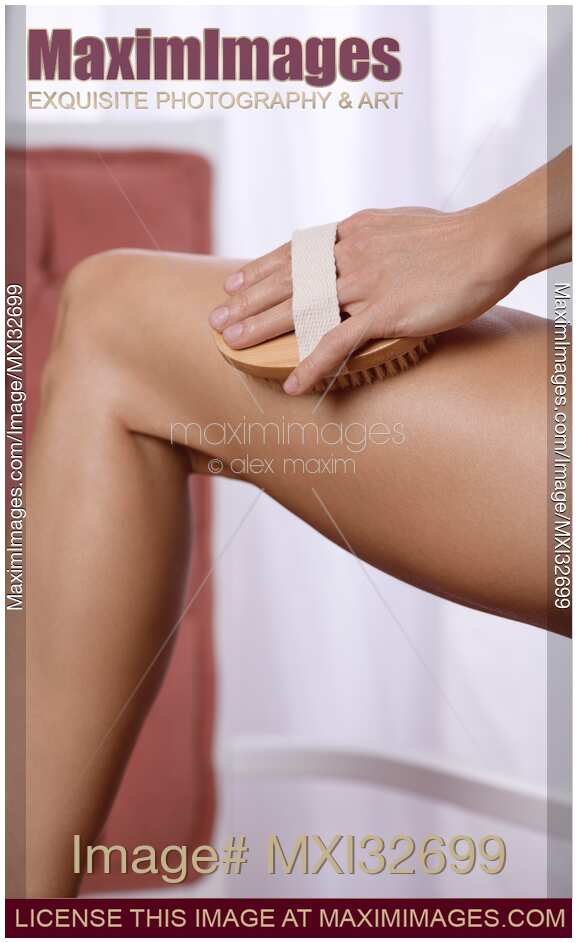 Woman dry brushing her legs Skin care and Beauty treatment
