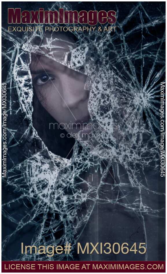 Woman face behind broken window glass with expressive look