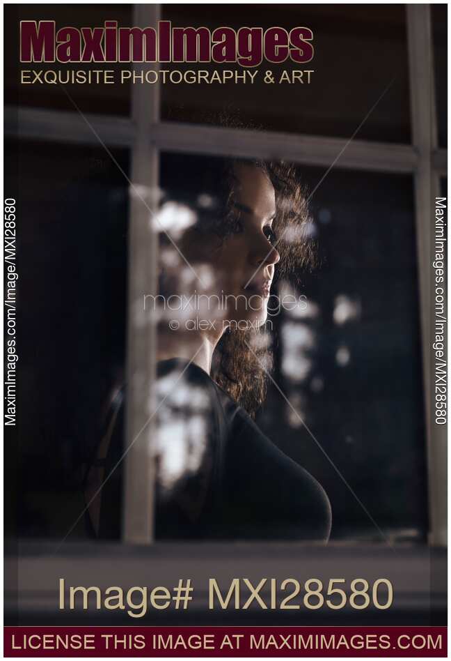 Woman face behind reflections on the window pane