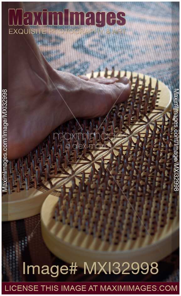 Woman foot standing on Sadhu Board Yogic board of nails Closeup