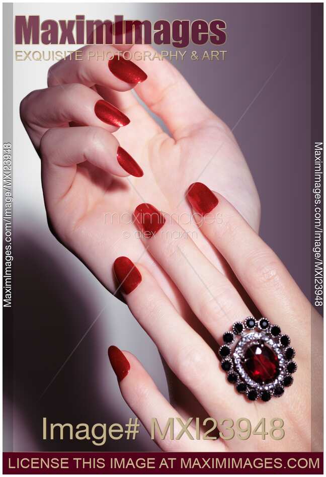 Woman hands with red nail polish and a ring