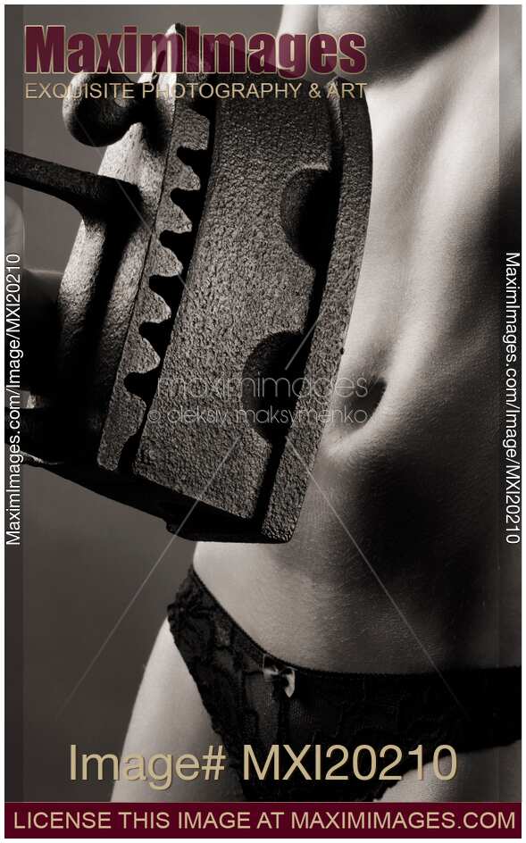 Woman holding antique flat iron in front of her bare stomach