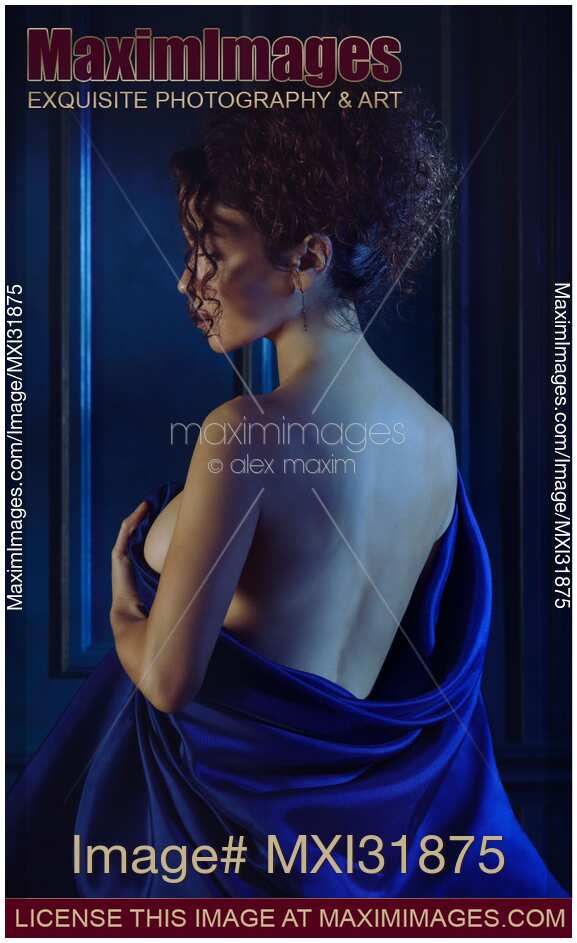 Woman holding bed sheets wrapped around her nude body revealing her naked back Sensual portrait