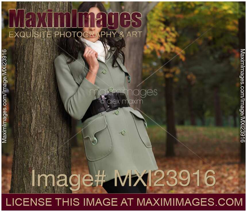 Woman in a Fall Season Coat Leaning Against a Tree