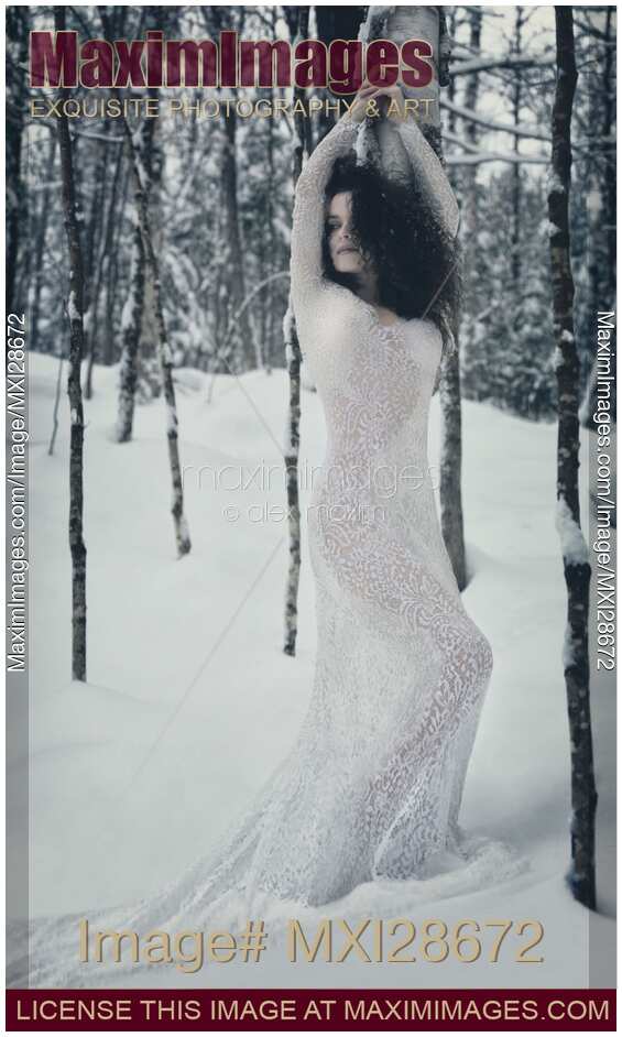 Woman in white lace dress in snowy winter nature scenery
