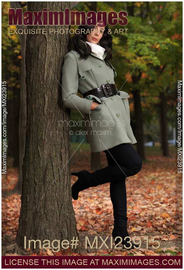 Woman Leaning Against a Tree in Autumn Park