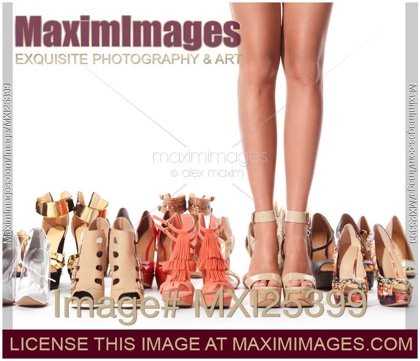 Woman legs surronded by many different shoes